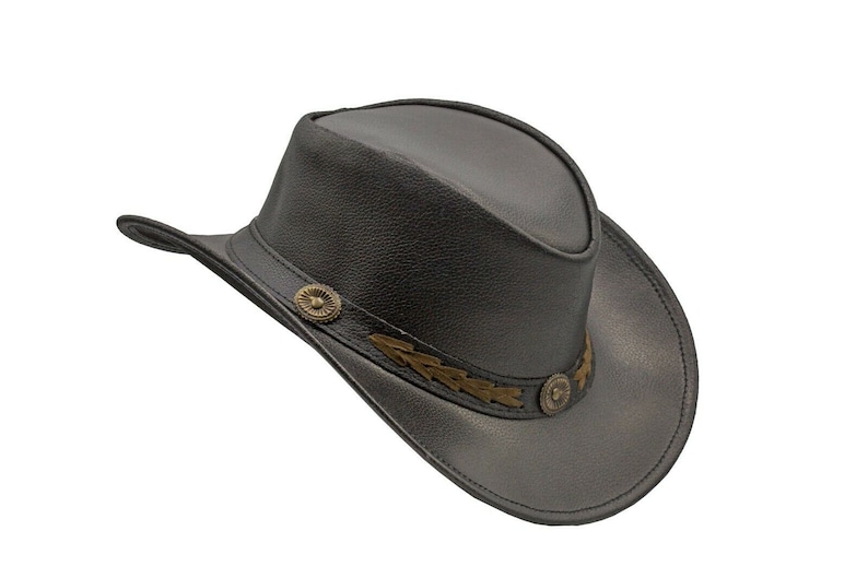 K&ouml;nnte beinhalten: Ein schwarzer Cowboyhut aus Leder mit einem braunen Lederband und goldenen Verzierungen.