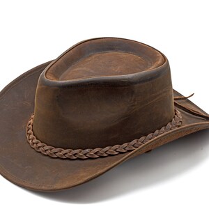 May include: A brown leather cowboy hat with a braided leather band.