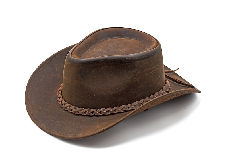 May include: A brown leather cowboy hat with a braided leather band.