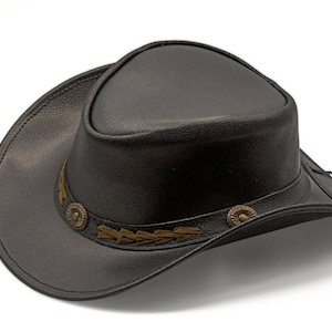 K&ouml;nnte beinhalten: Ein schwarzer Cowboyhut aus Leder mit einem braunen Lederband und dekorativen N&auml;hten.