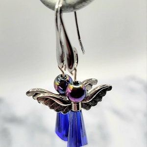 May include: A pair of silver angel dangle earrings with iridescent blue glass beads and blue crystal drops.