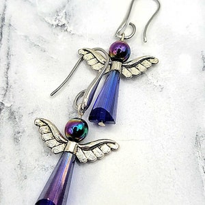 May include: A pair of silver angel earrings with iridescent blue crystal drops and black beads.