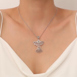 Pu&ograve; includere: Una collana con ciondolo a forma di angelo in filigrana d'argento. L'angelo &egrave; decorato con disegni intricati e ha un aspetto delicato e femminile.
