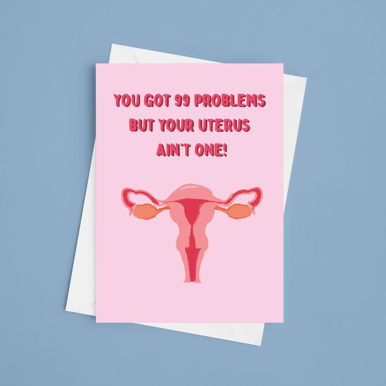 May include: A pink greeting card with the text "YOU GOT 99 PROBLEMS BUT YOUR UTERUS AIN'T ONE!" and a stylized illustration of a uterus. The card is inside a white envelope, set against a blue background.