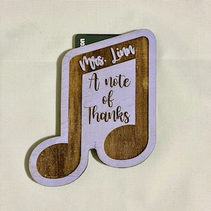 May include: A wooden music note gift card holder with a purple background and the text "Mrs. Linn A note of thanks".