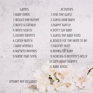 May include: A white card with a list of baby shower games and activities, including "Baby Items," "Word Scramble," and "Guess How Many." The text is in black, with the words "Games" and "Activities" at the top. White flowers are at the bottom.