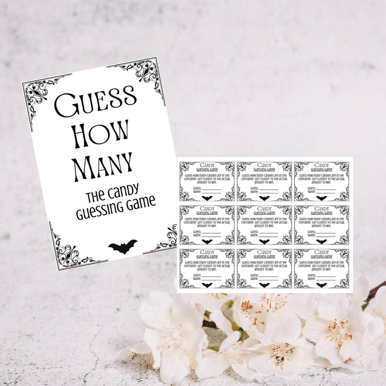 May include: A black and white "Guess How Many" candy guessing game set. The set includes a decorative sign with the game title and a bat silhouette, along with several matching guess cards.
