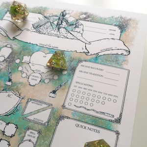 Op de afbeelding: Een personageblad voor een Dungeons and Dragons spel, met een afbeelding van een tovenaar. Het blad bevat vakjes voor de naam van het personage, hitpoints, doodsworpen, bepantsering, beweging, initiatief, spreuk reddingsworp, arcane recovery, arcane traditie, spreukwerping en snelle notities. Er liggen ook twee dobbelstenen, een groene en een gouden, op het blad.