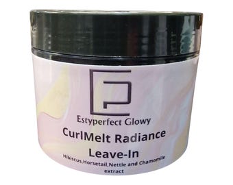 Op de afbeelding: Een cilindrische pot met een zwart deksel en een wit etiket. Het etiket bevat de tekst "Estyperfect Glowy CurlMelt Radiance Leave-In" met de ingrediënten hieronder vermeld. De pot heeft een lichtroze en gele gradiënt achtergrond.