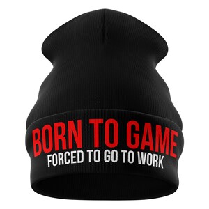 Puede incluir: Gorro negro con el texto "BORN TO GAME" en rojo y "FORCED TO GO TO WORK" en blanco. El gorro está hecho de un material de punto suave, ideal para el uso diario.