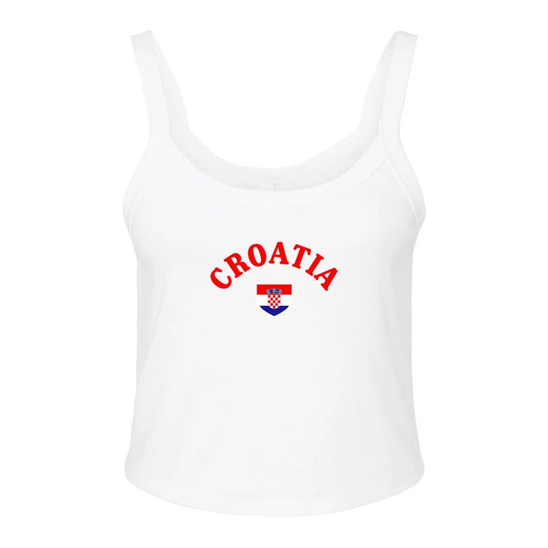 May include: White tank top with the word "Croatia" in red arched across the chest. Below the text is a small emblem of the Croatian flag. The tank top has a scoop neck and wide straps.