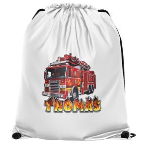 以下が含まれることがあります： 赤と黄色の消防車が描かれた白い巾着袋。「THOMAS」という名前が炎の文字で書かれています。黒い巾着の留め具。