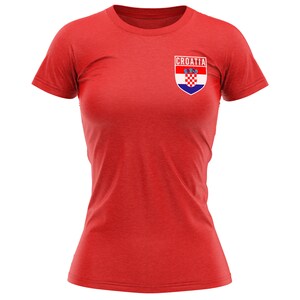 May include: Red t-shirt with a white and blue Croatian flag patch on the left chest. The patch has the word "CROATIA" above the flag.
