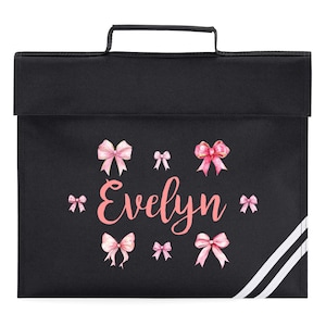 May include: Black school satchel with a top handle and a flap closure. The satchel is decorated with pink bows and the name "Evelyn" in a cursive font. White stripes run down the right side of the bag.