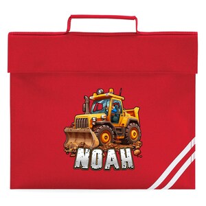 May include: A red school bag with a yellow cartoon bulldozer graphic. The bulldozer has a driver and the name "NOAH" in white block letters. The bag has a handle and white stripes on the side.