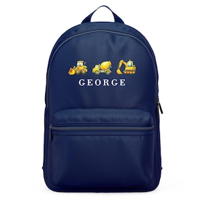 May include: Navy blue backpack featuring illustrations of construction vehicles in yellow and black. The name "GEORGE" is printed in white below the vehicles. The backpack has a top handle and a front pocket.
