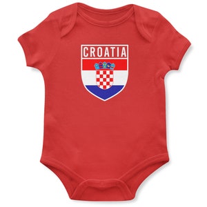 May include: Red baby onesie with a white shield featuring the Croatian flag and the word "CROATIA" above it.