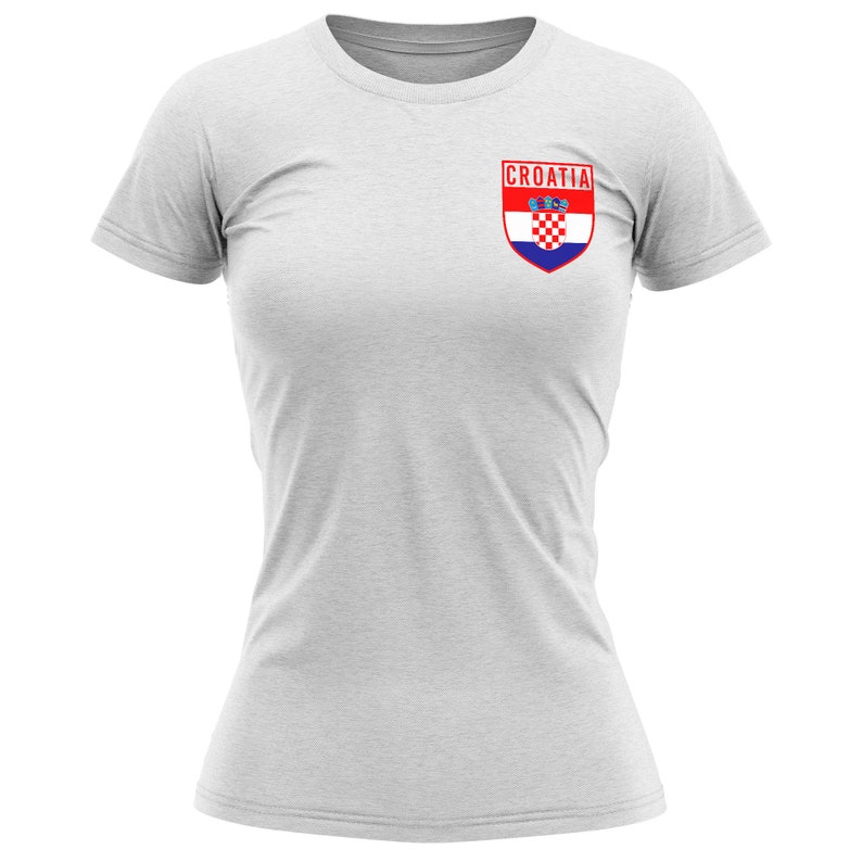 May include: A white t-shirt with a red and blue Croatian flag patch on the left chest. The patch has the word "CROATIA" above the flag.