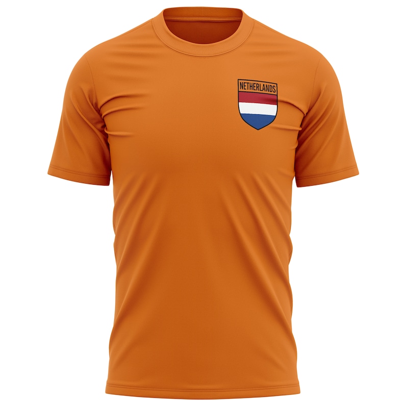Pode incluir: Camiseta laranja com um pequeno patch bordado com a bandeira holandesa e a palavra "Pa&iacute;ses Baixos" nele.