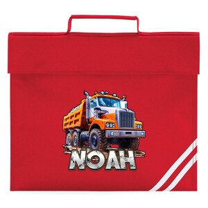 May include: Red school bag featuring a colorful illustration of an orange and white dump truck carrying a load of dirt. The name "NOAH" is printed in a stylized font below the truck. The bag has a handle and white stripes on the side.