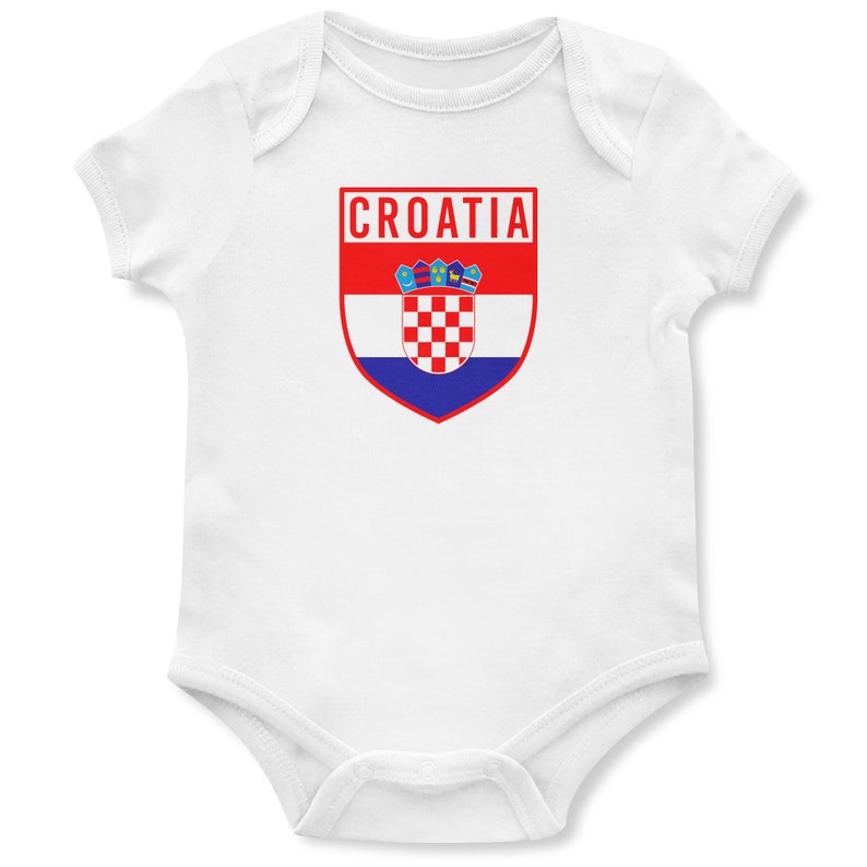 May include: White baby onesie with a red, white, and blue shield featuring the Croatian flag and the word "CROATIA" in red letters.