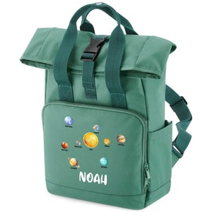 May include: A green canvas backpack with a roll-top closure and a zipped pocket. The backpack features a colourful graphic of the planets in our solar system and the name "NOAH" printed in white.