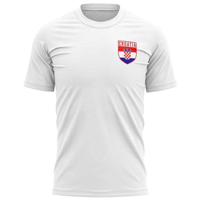 May include: White t-shirt with a small, red, white, and blue Croatian flag patch on the left chest. The patch has the word "CROATIA" above the flag.