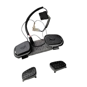 May include: A set of four black plastic buttons with a raised design. The buttons are connected by a black wire with a small black box.