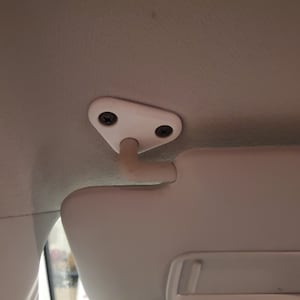 May include: White car sun visor with a white plastic hook and two screws.