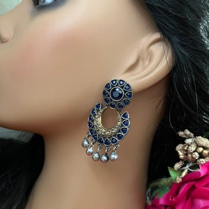 May include: Silver and gold tone earrings with a blue gemstone cluster and dangling silver beads.