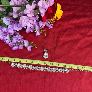 May include: A silver necklace with clear crystal stones and matching earrings. The necklace is 19 inches long and features a delicate chain with a row of hexagonal stones. The earrings are small and dangle from silver hooks.