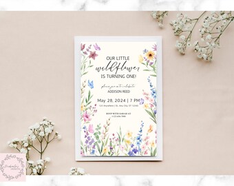 May include: A floral-themed invitation card with the text "OUR LITTLE wildflower IS TURNING ONE!" in a whimsical font. The card features watercolor illustrations of wildflowers and butterflies, with the event details: May 28, 2024, 7 PM.