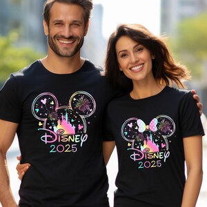 May include: Two black t-shirts with a colorful graphic of the Disney castle and Mickey Mouse ears. The text "Disney 2025" is printed on the shirts.