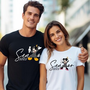 May include: Two people wearing black and white t-shirts with a Mickey Mouse and Minnie Mouse graduation design. The shirts say "Senior 2023".