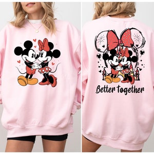 May include: Pink sweatshirt with a graphic of Mickey and Minnie Mouse on the front and the text "Better Together" on the back.
