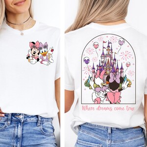 Pu&ograve; includere: Maglietta bianca con un'immagine di Topolino e Minnie Mouse davanti al Castello di Cenerentola. Il retro della maglietta ha un'immagine di Topolino e Minnie Mouse davanti al Castello di Cenerentola con fuochi d'artificio e il testo "Where dreams come true".