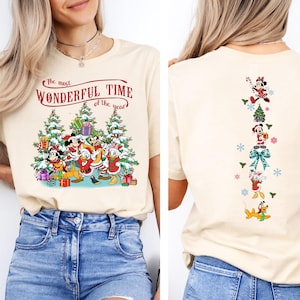 Puede incluir: Camiseta beige con un dise&ntilde;o navide&ntilde;o de Disney. La parte delantera muestra a Mickey y Minnie Mouse, el Pato Donald y Goofy con el texto "The most Wonderful Time of the year". La parte trasera tiene una disposici&oacute;n vertical de personajes.