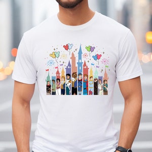 Puede incluir: Camiseta blanca con una ilustraci&oacute;n colorida del castillo de Disney y los pr&iacute;ncipes. El castillo est&aacute; rodeado de globos y fuegos artificiales.