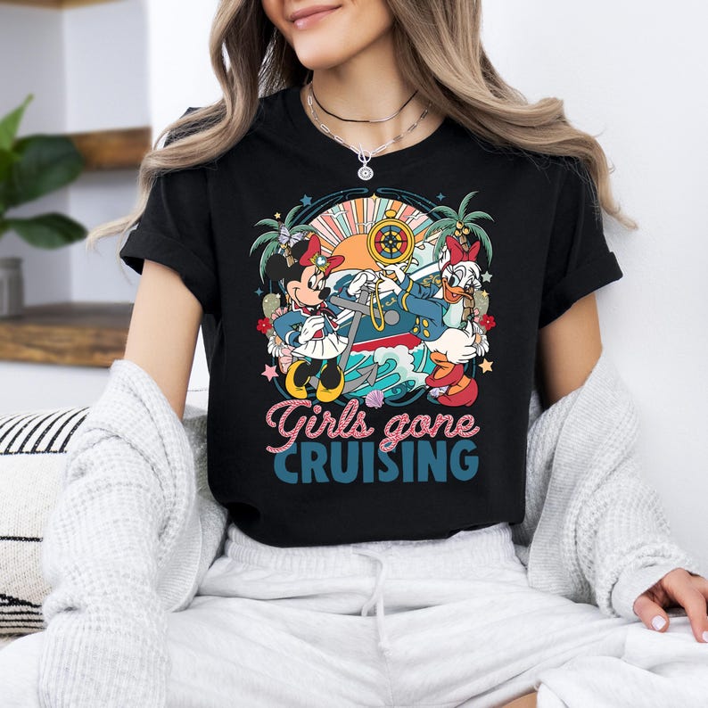 May include: Black t-shirt with a colorful graphic of Mickey Mouse and Minnie Mouse dressed as sailors on a boat. The text "Girls gone cruising" is printed below the graphic.
