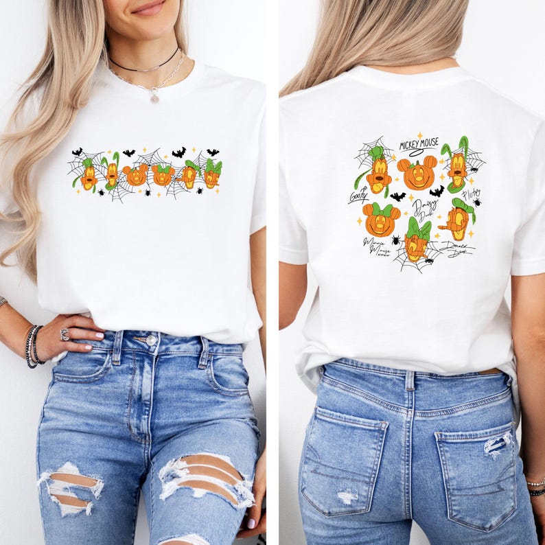 May include: White t-shirt featuring a Halloween-themed design with cartoon characters and pumpkins. The front of the shirt displays a row of pumpkins with spiderwebs and bats. The back of the shirt has Mickey Mouse and other characters.