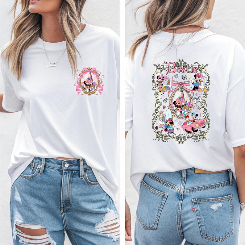 May include: White t-shirt with a pink and gold design featuring Mickey Mouse and Minnie Mouse characters. The back of the shirt has a larger design with the word "Bestie" and more characters.