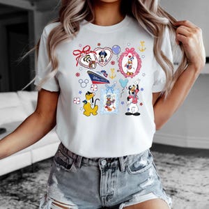 Puede incluir: Camiseta blanca con un estampado gr&aacute;fico colorido de personajes de Disney, incluyendo Mickey Mouse, Minnie Mouse, Donald Duck, Goofy y Pluto. El gr&aacute;fico incluye corazones, estrellas, anclas y un crucero con el texto "Disney Cruise Line".
