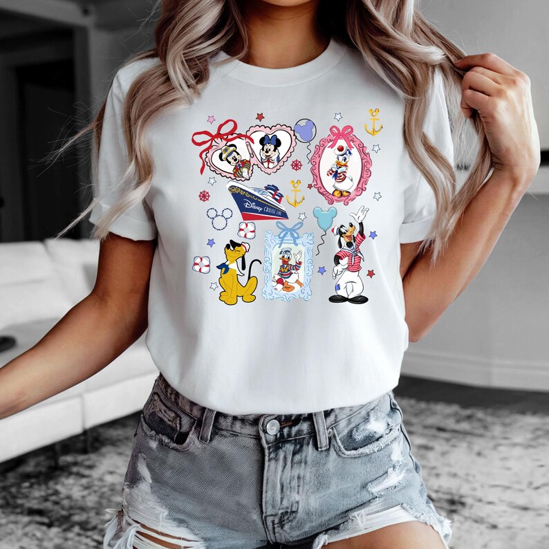 Puede incluir: Camiseta blanca con un estampado gr&aacute;fico colorido de personajes de Disney, incluyendo Mickey Mouse, Minnie Mouse, Donald Duck, Goofy y Pluto. El gr&aacute;fico incluye corazones, estrellas, anclas y un crucero con el texto "Disney Cruise Line".