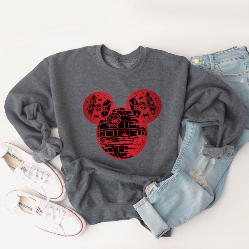 May include: A gray sweatshirt with a red and black Mickey Mouse design featuring the Death Star from Star Wars.