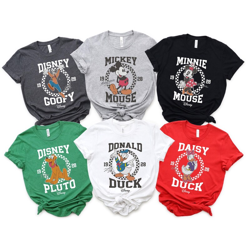 May include: Six different t-shirts featuring Disney characters. The shirts are all white, grey, black, green, and red. Each shirt has a different character, including Mickey Mouse, Minnie Mouse, Goofy, Pluto, Donald Duck, and Daisy Duck. The shirts all have a vintage-inspired design with the character's name and the years 19 and 28.