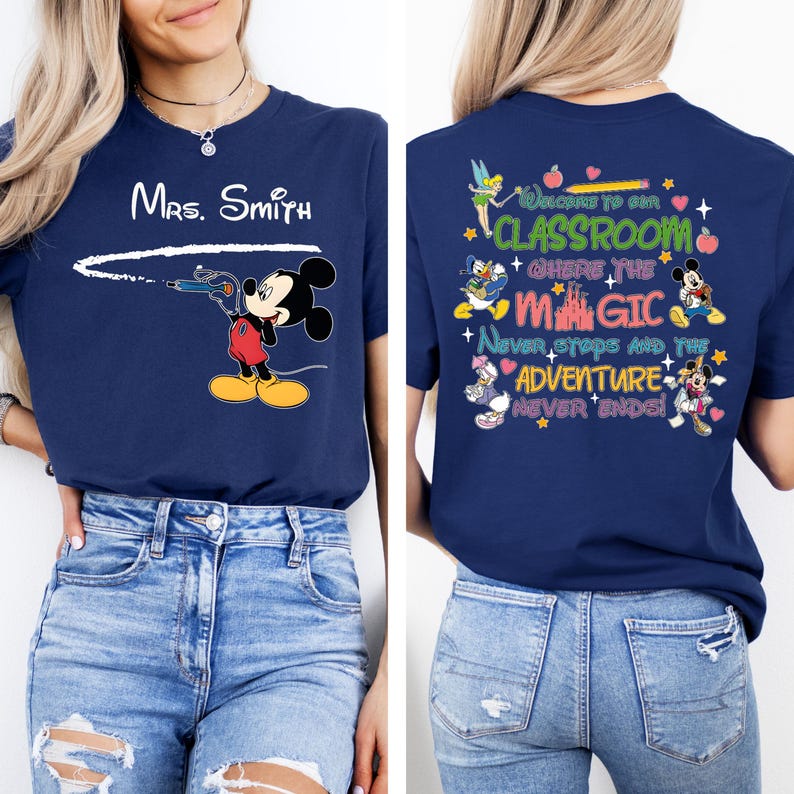 May include: A navy blue t-shirt with a Mickey Mouse design on the front and a Disney-themed classroom quote on the back. The quote reads "Welcome to our classroom where the magic never stops and the adventure never ends!"