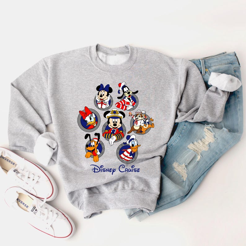 May include: A gray sweatshirt featuring Disney characters in sailor outfits. The design includes Mickey Mouse, Minnie Mouse, Donald Duck, Daisy Duck, Goofy, Pluto, and Chip and Dale. The words "Disney Cruise" are printed below the characters.