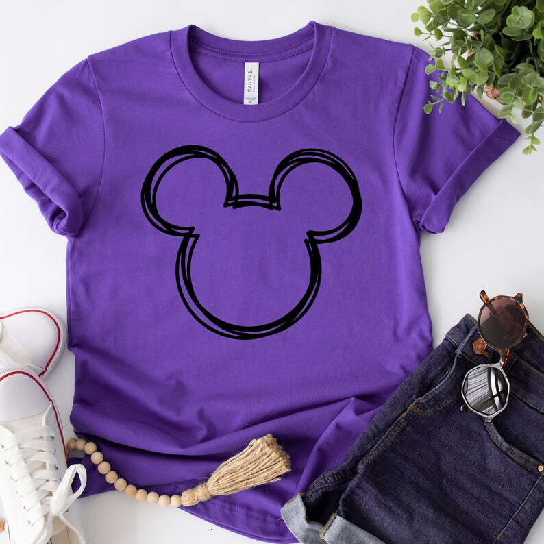 May include: Purple t-shirt with a black outline of Mickey Mouse ears.