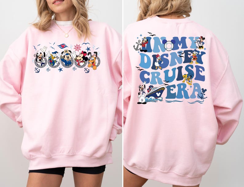 May include: Pink sweatshirt with a graphic of Mickey Mouse and friends on a cruise ship on the front and the text "In My Disney Cruise Era" on the back.