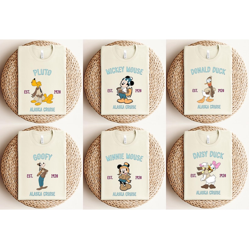 May include: Six cream-colored t-shirts featuring Disney characters Pluto, Mickey Mouse, Donald Duck, Goofy, Minnie Mouse, and Daisy Duck. Each shirt has a character graphic, the text "EST. 1928", and "ALASKA CRUISE" in a light blue font.